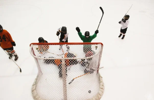 Hockey players celebrating a goal with sticks raised